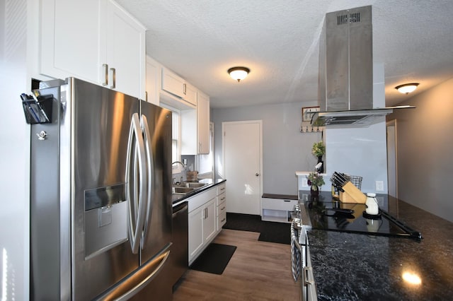 kitchen featuring sink, white cabinetry, island range hood, dark stone counters, and stainless steel appliances