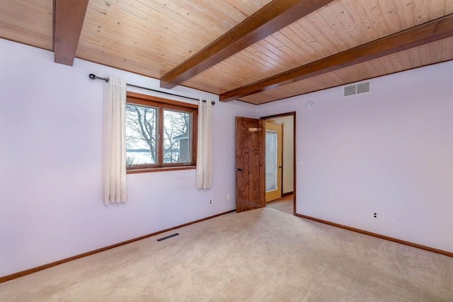 carpeted empty room featuring beam ceiling and wooden ceiling