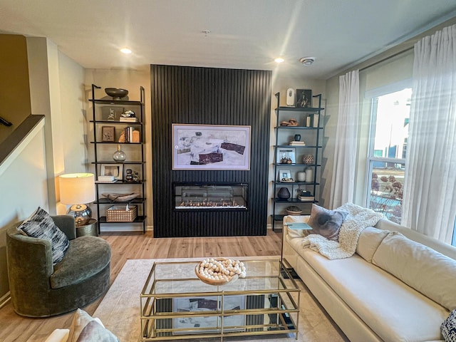 living room with a large fireplace and light wood-type flooring