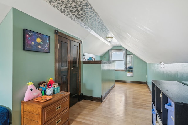 bonus room featuring vaulted ceiling, baseboards, and light wood finished floors