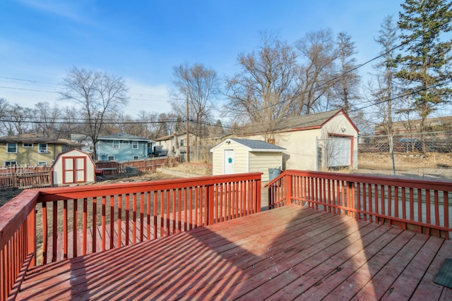 wooden terrace featuring a residential view, fence, an outdoor structure, and a shed