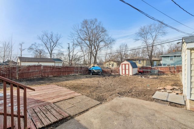 view of yard with a storage shed, a fenced backyard, and an outdoor structure