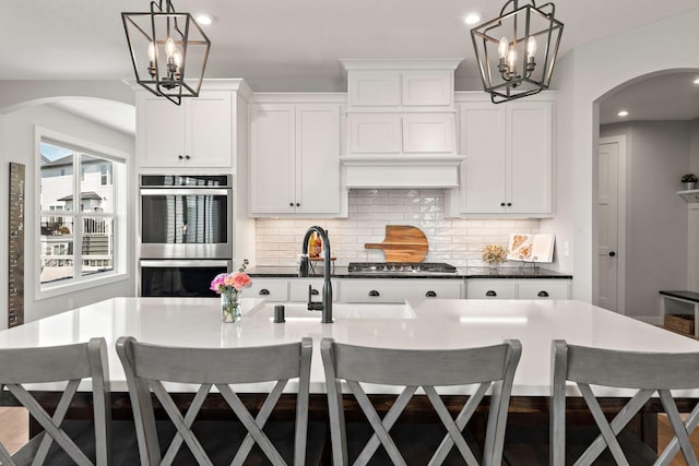 kitchen featuring an island with sink, appliances with stainless steel finishes, and a breakfast bar