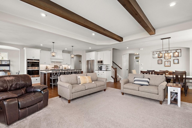 living room with beam ceiling and light wood-type flooring