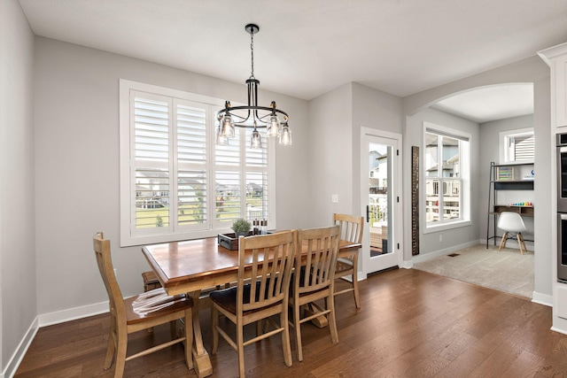 dining area with a chandelier and dark hardwood / wood-style flooring