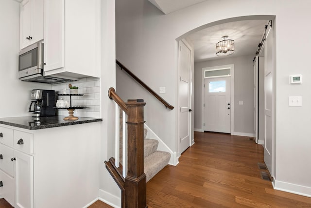 foyer entrance with dark hardwood / wood-style floors and a barn door