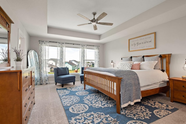 bedroom featuring a raised ceiling and ceiling fan