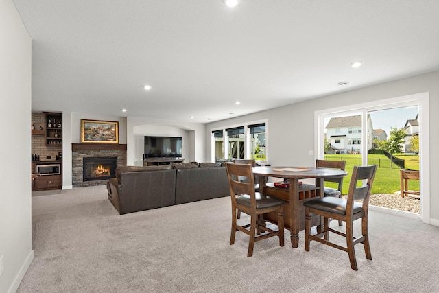 carpeted dining area featuring a wealth of natural light and a fireplace