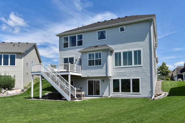 rear view of house featuring a wooden deck and a lawn