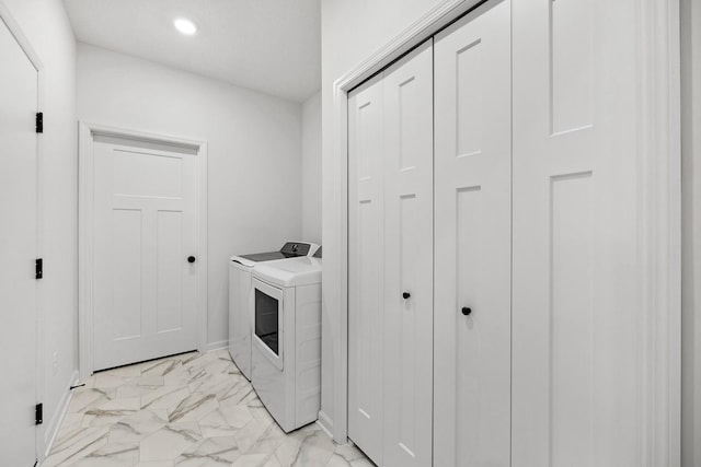 washroom featuring laundry area, baseboards, marble finish floor, and washing machine and clothes dryer