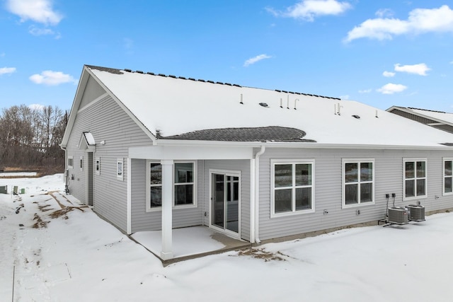 snow covered house with a patio and central AC