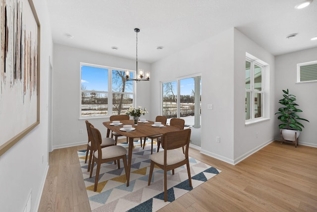 dining space with recessed lighting, a notable chandelier, light wood-style flooring, and baseboards