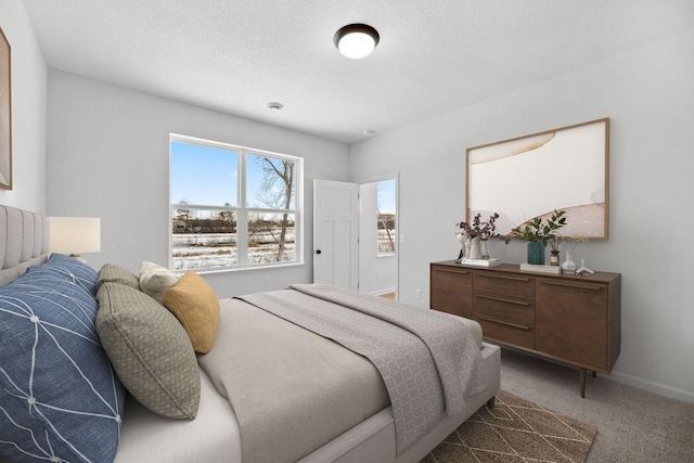 carpeted bedroom with a textured ceiling and baseboards