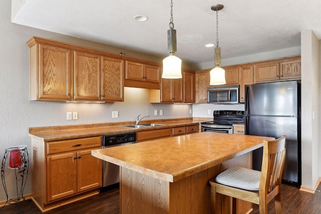 kitchen with sink, hanging light fixtures, stainless steel appliances, a center island, and dark hardwood / wood-style flooring