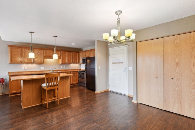 kitchen with appliances with stainless steel finishes, decorative light fixtures, sink, a center island, and dark wood-type flooring