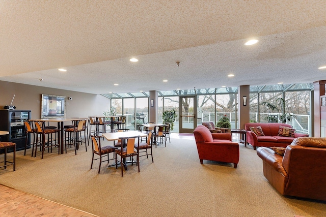 dining room with a wall of windows, light carpet, and a textured ceiling