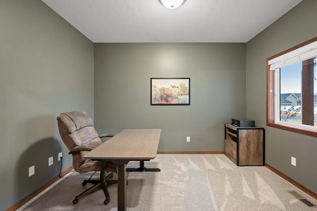 carpeted office featuring a textured ceiling, visible vents, and baseboards