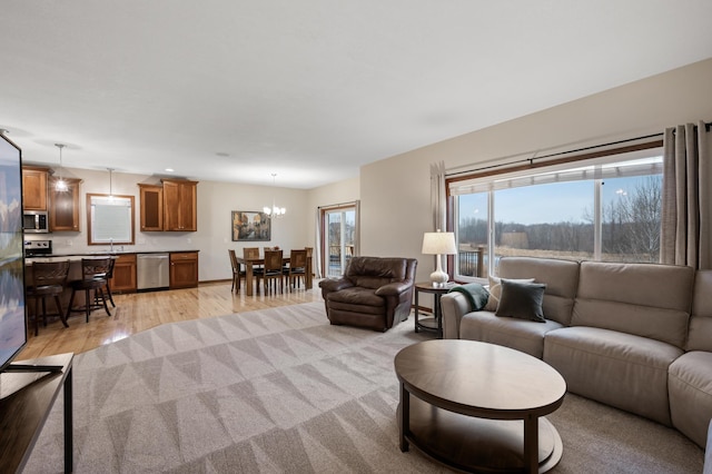 living area with an inviting chandelier and light wood-style flooring