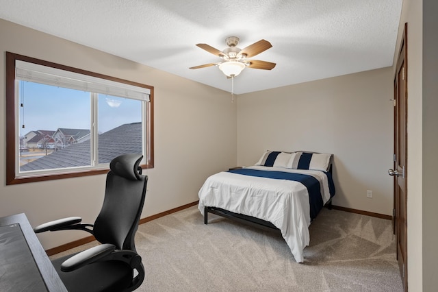 bedroom featuring baseboards, a textured ceiling, and light colored carpet