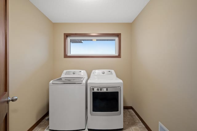 laundry room featuring laundry area, light tile patterned floors, baseboards, and separate washer and dryer