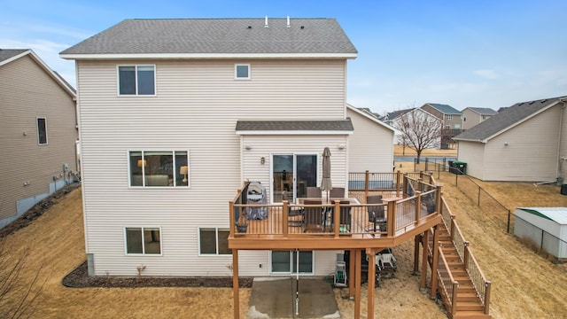 back of house with a shingled roof, stairway, a patio, and a wooden deck