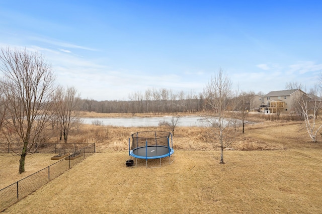 view of yard featuring a trampoline and fence