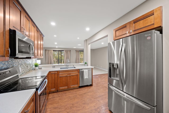 9700 Portland Ave S Unit 226, Bloomington, MN 55420 - kitchen featuring appliances with stainless steel finishes, a sink, light wood-style floors, brown cabinets, and light countertops