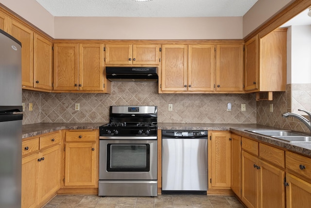 kitchen featuring appliances with stainless steel finishes, range hood, sink, and backsplash