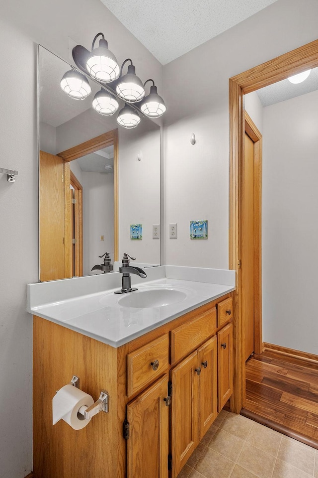 bathroom with vanity, tile patterned flooring, and a textured ceiling