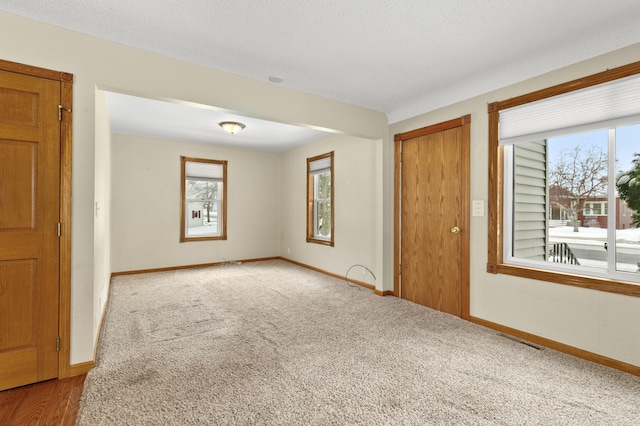 spare room featuring light carpet and a textured ceiling