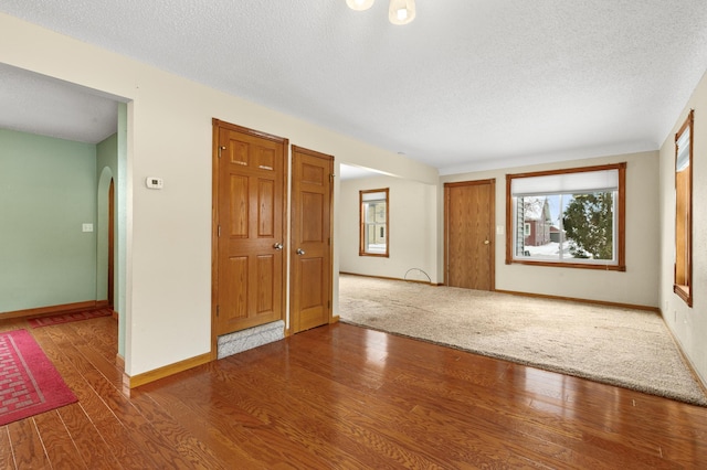 unfurnished room with hardwood / wood-style floors and a textured ceiling