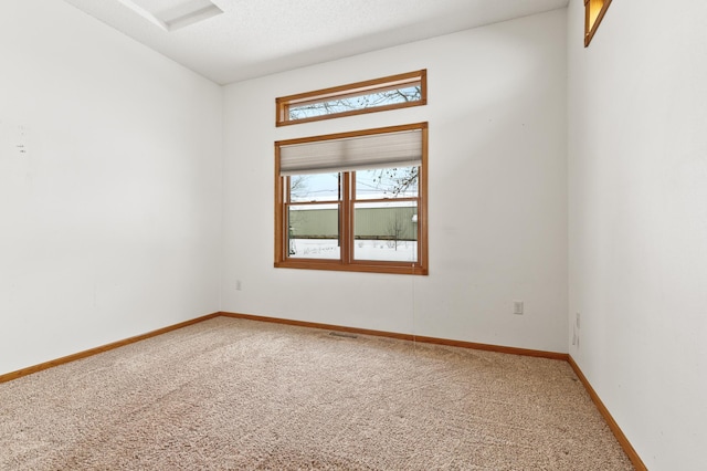 unfurnished room with a textured ceiling and carpet flooring