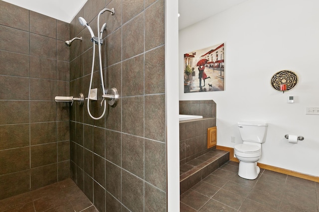 bathroom featuring a tile shower, tile patterned floors, and toilet