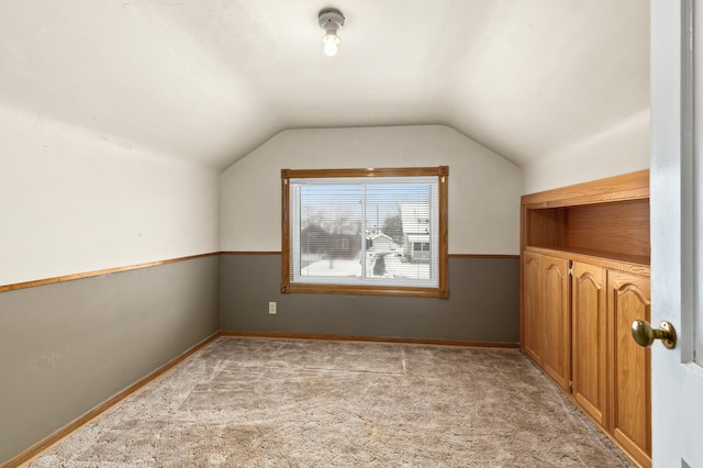 additional living space with vaulted ceiling and light colored carpet