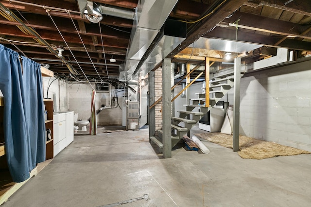 basement featuring heating unit and washer and clothes dryer