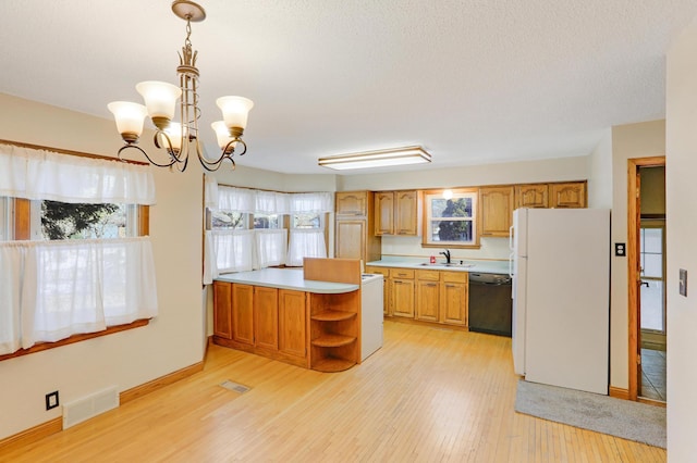 kitchen featuring pendant lighting, sink, light hardwood / wood-style flooring, black dishwasher, and white fridge