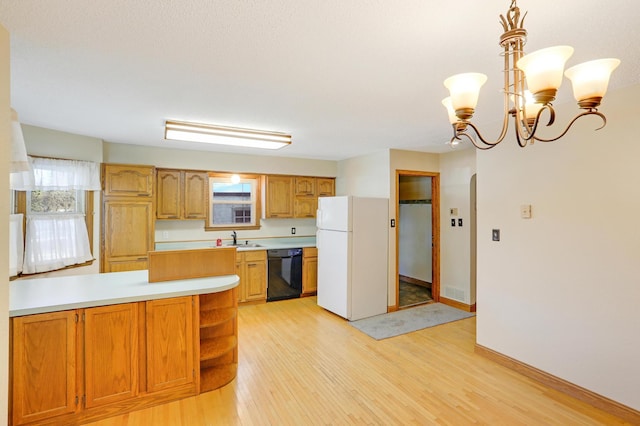 kitchen with pendant lighting, black dishwasher, sink, white fridge, and light hardwood / wood-style flooring