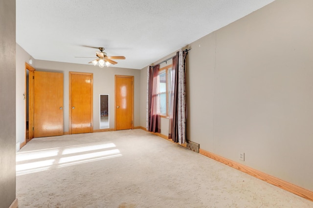 carpeted spare room with a textured ceiling and ceiling fan