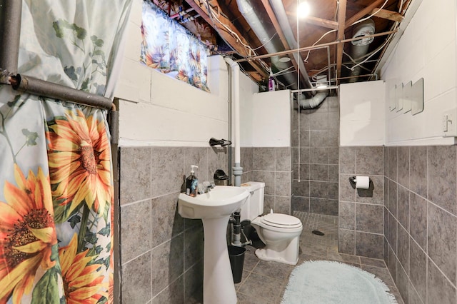 bathroom featuring tile patterned flooring, tile walls, and toilet