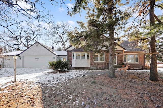 view of front of property featuring brick siding and a garage