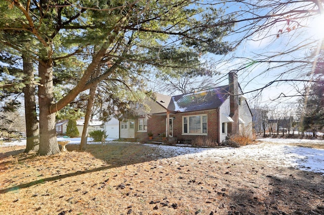 view of front of house with brick siding and a chimney