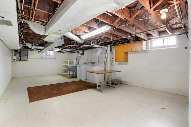 below grade area with tile patterned floors, electric panel, washing machine and dryer, and a sink