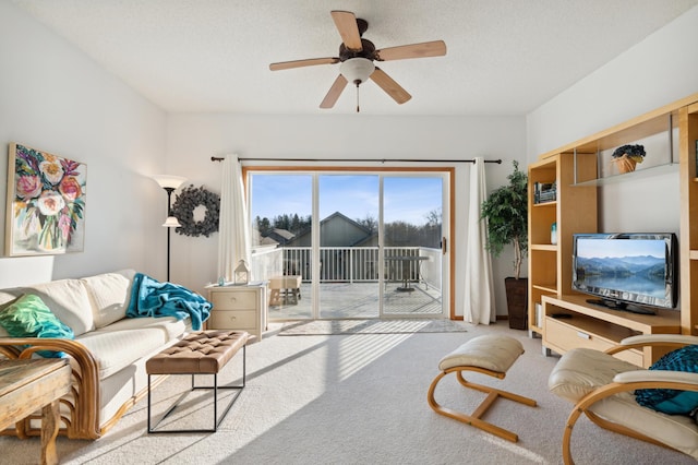 carpeted living room with ceiling fan and a textured ceiling