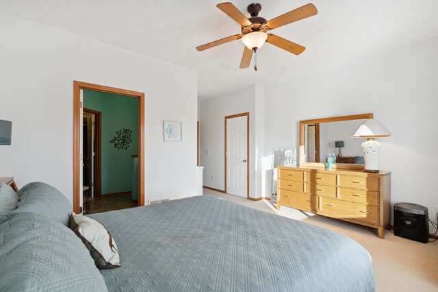 bedroom with light carpet, visible vents, and a ceiling fan