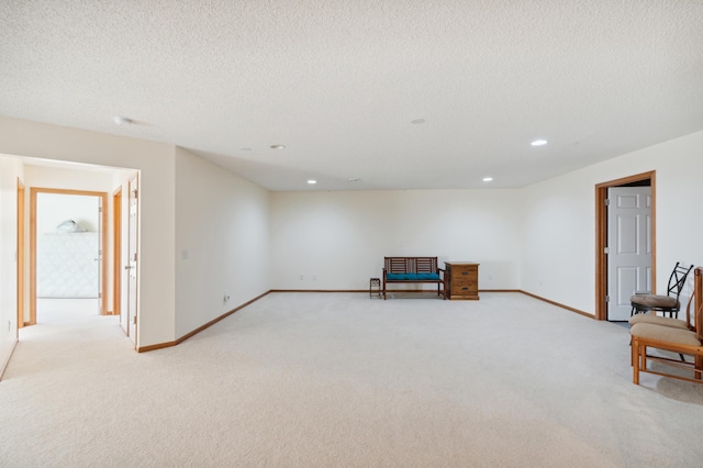 living area with recessed lighting, baseboards, a textured ceiling, and light colored carpet