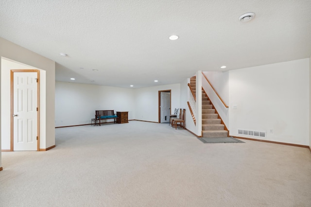 below grade area featuring recessed lighting, carpet flooring, visible vents, baseboards, and stairs