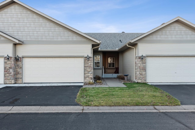 single story home featuring a garage, driveway, and roof with shingles