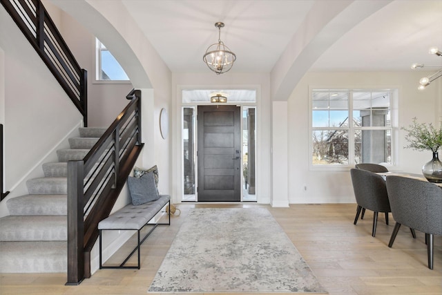 entryway with an inviting chandelier and light hardwood / wood-style floors