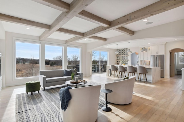 living room featuring beamed ceiling, coffered ceiling, and light hardwood / wood-style flooring