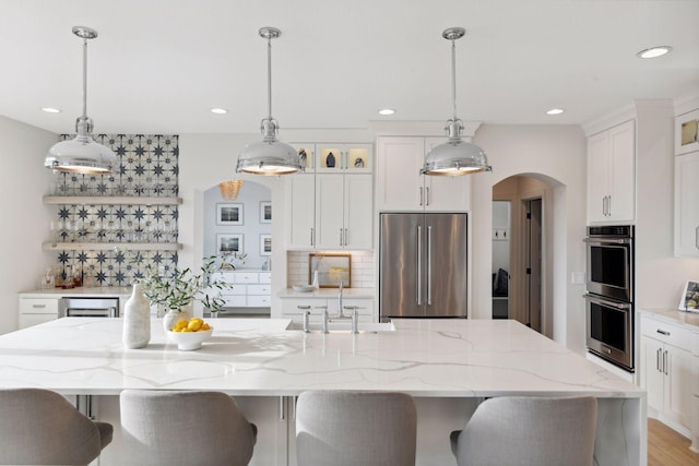 kitchen with a large island, pendant lighting, and appliances with stainless steel finishes